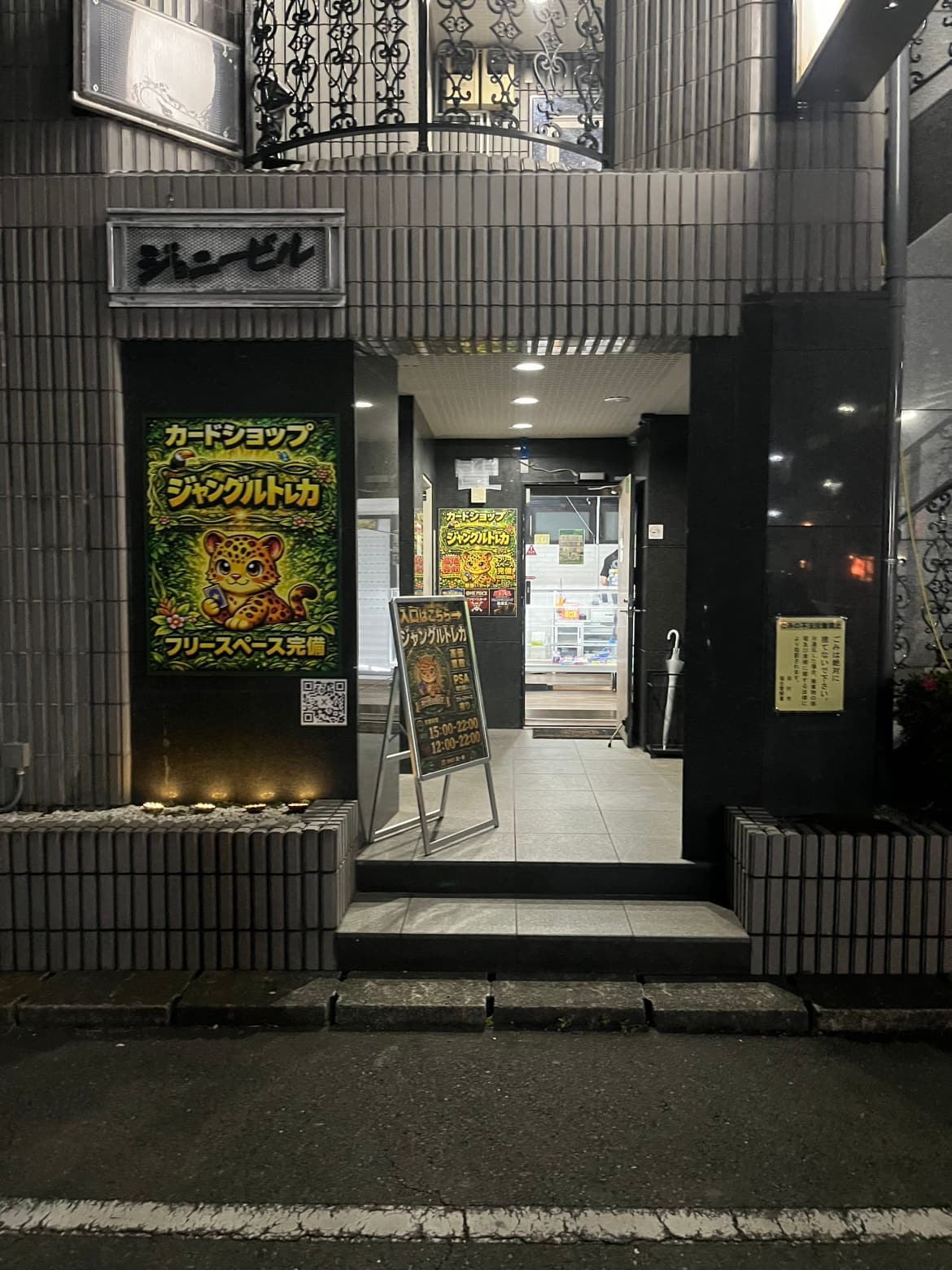 夜のジョニービル入口、看板が灯る店舗外観
