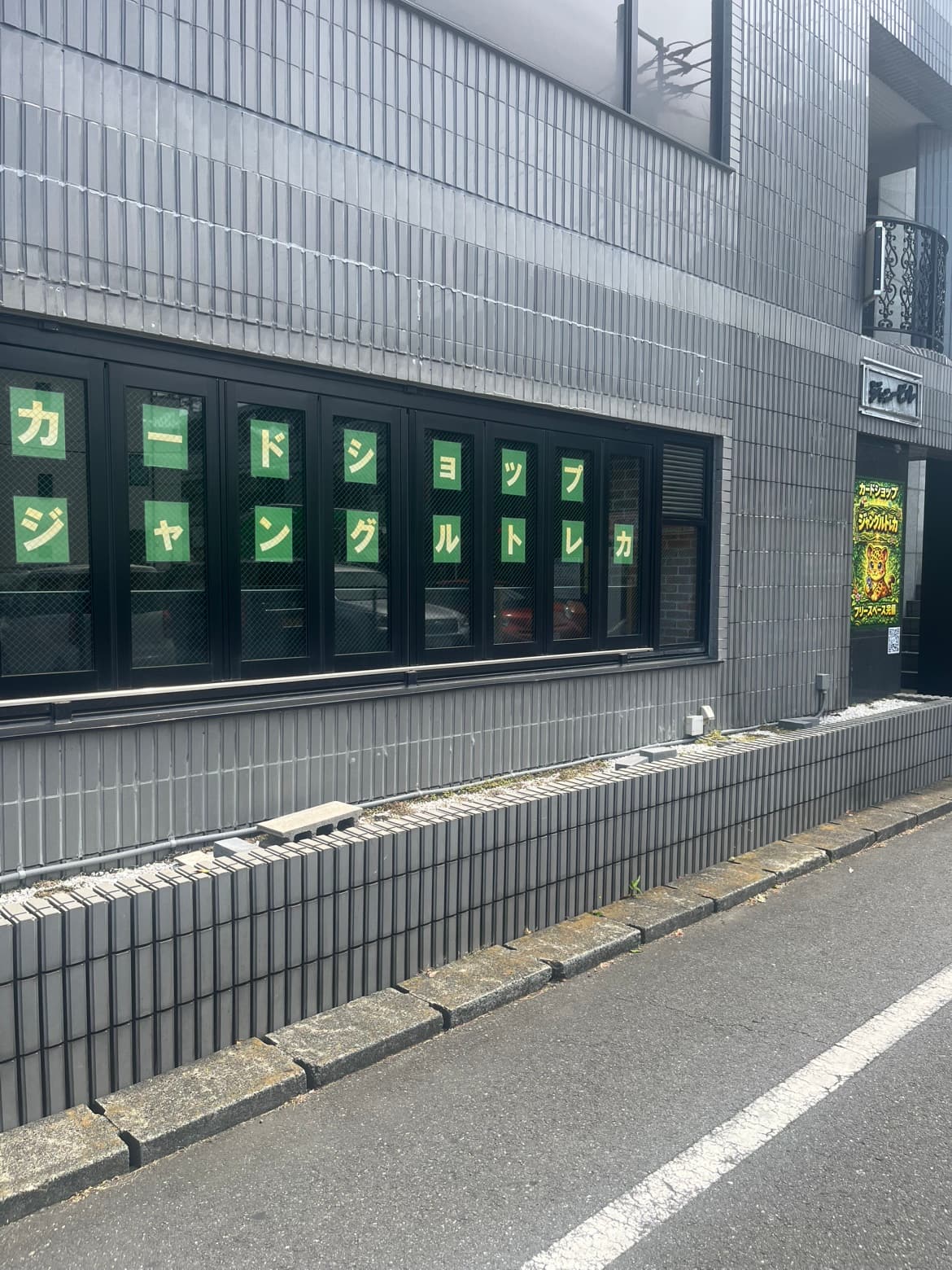 店舗外観：窓に掲げられた「カードショップ ジャングルトレカ」の文字